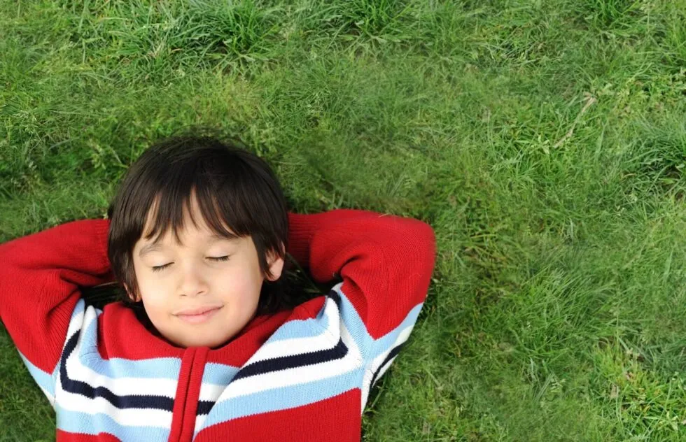 niño descansando en la hierba
